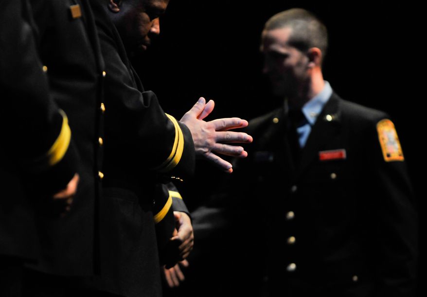 A D.C. Fire &amp; Emergency Medical Services recruit goes down the line shaking hands as D.C. Fire &amp; Emergency Medical Services Medical Director Dr. David A. Miramontes awaits his congratulatory handshake at the Recruit Class 367 Graduation Ceremony at Gallaudet University in Northeast on April 17. Khalid Naji-Allah /Special to The Washington Times