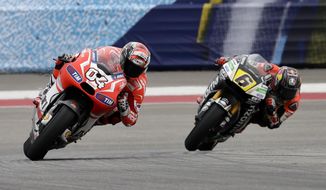 Andrea Dovizioso of Italy leads Stefan Bradl (6) of Germany out of Turn 5 during the Grand Prix of the Americas MotoGP motorcycle race, Sunday, April 13, 2014, in Austin, Texas. Dovizioso finished third in the race.  (AP Photo/Tony Gutierrez)