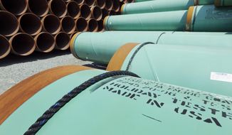 This May 24, 2012, file photo shows some of about 500 miles worth of coated steel pipe manufactured by Welspun Pipes, Inc., originally for the Keystone oil pipeline, stored in Little Rock, Ark. (AP Photo/Danny Johnston, File)