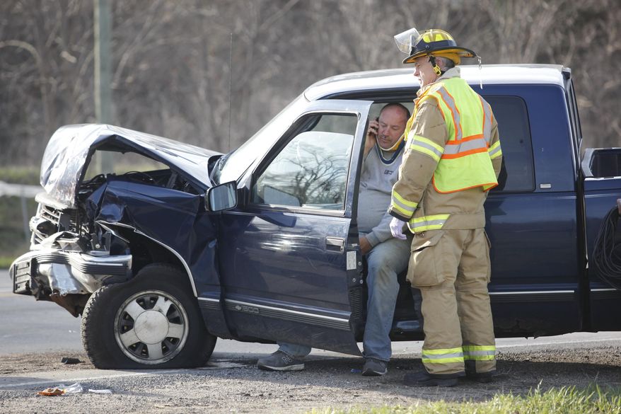 In this April 17, 2014 photo, a firefighter talks to a person near Comstock Township, Mich., following two accidents. A western Michigan volunteer firefighter responding to a head-on crash in Kalamazoo County struck another vehicle, fatally injuring the driver. (AP Photo/Kalamazoo Gazette-MLive Media Group, Mark Bugnaski)