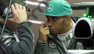 Mercedes driver Lewis Hamilton of Britain chats with his crew inside the garage during the practice session ahead of Sunday&#39;s Chinese Formula One Grand Prix at Shanghai International Circuit in Shanghai, China Friday, April 18, 2014. (AP Photo/Andy Wong)