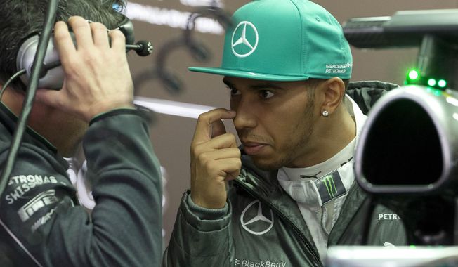 Mercedes driver Lewis Hamilton of Britain chats with his crew inside the garage during the practice session ahead of Sunday&#x27;s Chinese Formula One Grand Prix at Shanghai International Circuit in Shanghai, China Friday, April 18, 2014. (AP Photo/Andy Wong)