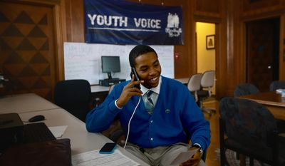 Michael Reynolds, 16, of Detroit,  a student at Loyola High School  makes calls Wednesday, April 16, 2014  to supporters to join him for the "Walk With Me" Michigan Education Rally  at Youth Voice, a project of the Harriet Tubman Center in Detroit. Youth Voice is a network for young people to develop their leadership skills and make community change. Youth Voice is planning a relay walk to Lansing from Detroit to raise awareness about disturbing trends associated with the Michigan Zero Tolerance Law and education.  (AP Photo/Detroit Free Press, Kimberly P. Mitchell)