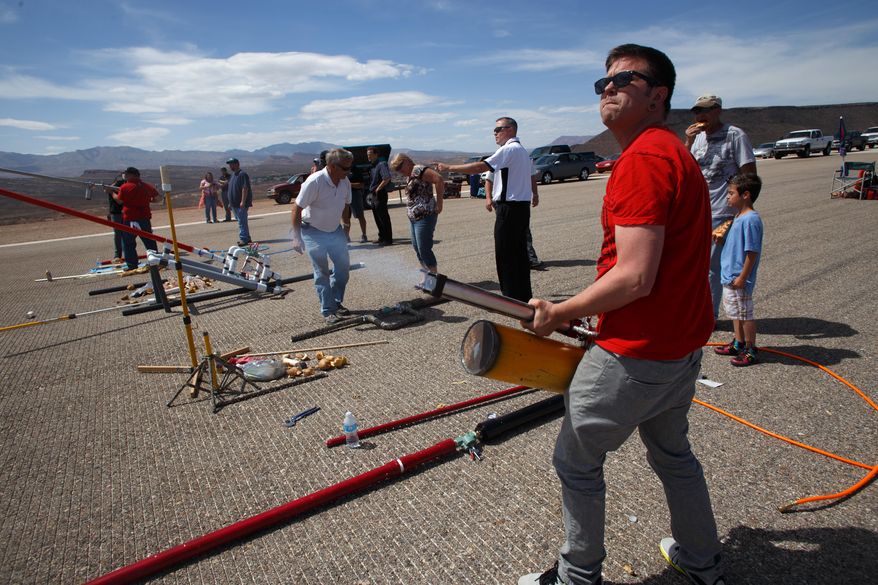 In an Wednesday, April 16, 2014 photo, Tyler Jewell, a student in an Industrial and Facilities Maintenance class at at Dixie Applied Technology College (DXATC), fires a potato cannon he built for the class, on the old St. George Airport runway. There was a competition to see who could make the vegetables fly the farthest at the south end of the old runway. Students majoring in industrial facilities maintenance are studying what's called fluid power, which includes hydraulic, pneumatic, pump and valve system science. (AP Photo/The Spectrum, Jud Burkett)