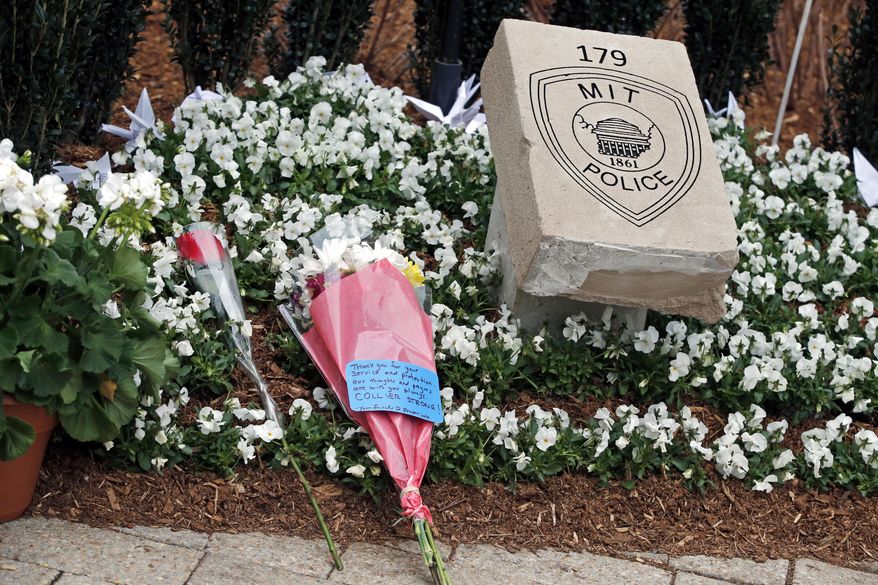 Flowers lay at a memorial stone after a one-year remembrance ceremony for Massachusetts Institute of Technology Officer Sean Collier on campus in Cambridge, Mass., Friday, April 18, 2014. Authorities say Collier was slain by the suspects of the 2013 Boston Marathon bombing. (AP Photo/Elise Amendola)
