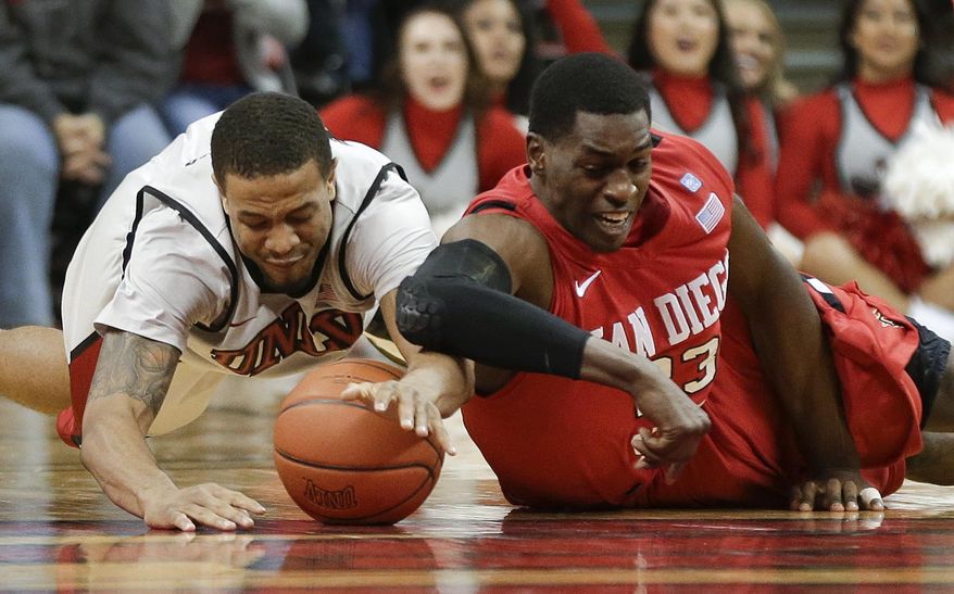ADVANCE FOR WEEKEND EDITIONS APRIL 20-21 - FILE - In this Feb. 16, 2013, file photo, UNLV's Bryce Dejean-Jones, left, and San Diego State's DeShawn Stephens dive for a loose ball in the second half of an NCAA college basketball game in Las Vegas. Division I coaches are realizing that they can win both now and later with transfers, who are suddenly viewed more like shiny new toys than damaged goods. A recent surge in player movement has turned the once-sleepy late signing period, which starts on Wednesday and runs through May 21, into a month-long free agent frenzy that's transformed the game. (AP Photo/Julie Jacobson, File)