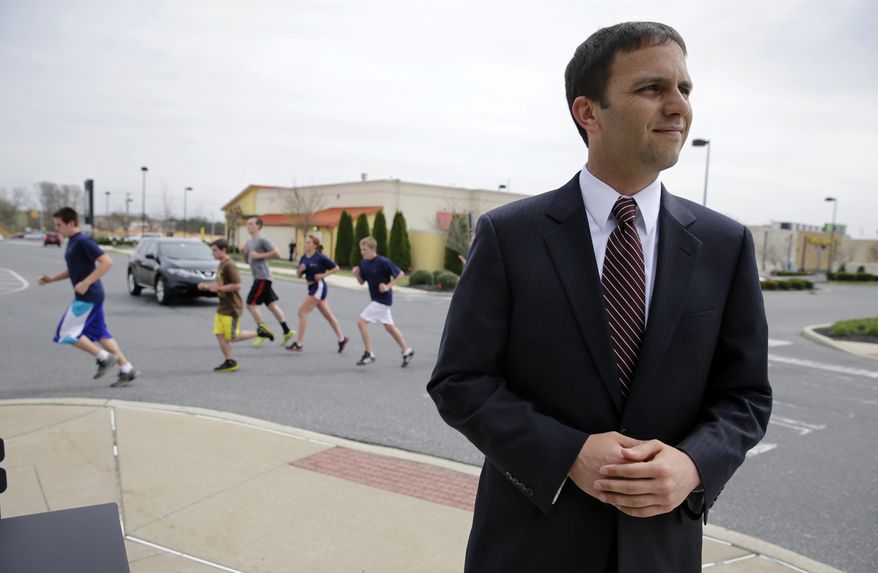 In this April 18, 2014 photo, as runners pass nearby, Frank Broomell Jr. listens to a question in Sicklersville, N.J. Broomell, a 27-year-old former Marine who is now working on his master’s degree at Harvard, is a Congressional candidate for New Jersey’s 1st District seat held since 1990 by Rob Andrews. Andrews announced on Feb. 4, that he was resigning. In the June 3, Democratic primary, Broomell will face Logan Township Mayor Frank Minor and state Sen. Donald Norcross. (AP Photo/Mel Evans)