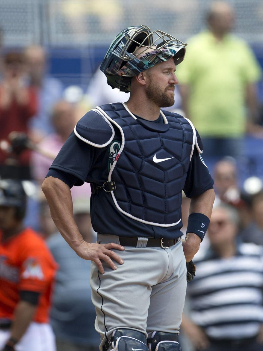 Seattle Mariners catcher John Buch reacts after an electronic review of a home plate play changed the official ruling from an out to a run scored for the Miami Marlins during the eighth inning of a baseball game in Miami, Sunday, April 20,2014. The Marlins won 3-2. (AP Photo/J Pat Carter)