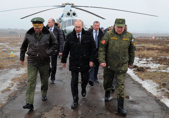 Russian President Vladimir Putin (center) and Defense Minister Sergei Shoigu (left) and the commander of the Western Military District, Anatoly Sidorov arrive to watch military exercises near St. Petersburg. Russia has shown off its new arsenal as it masses near Ukraine. (RIA-Novosti via Associated Press)