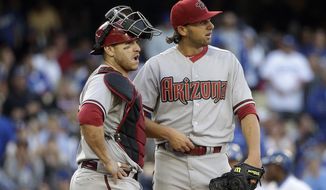 Arizona Diamondbacks starting pitcher Mike Bolsinger, right, and catcher Miguel Montero look at the scoreboard during the fifth inning of a baseball game against the Los Angeles Dodgers, Saturday, April 19, 2014, in Los Angeles. (AP Photo/Jae C. Hong)