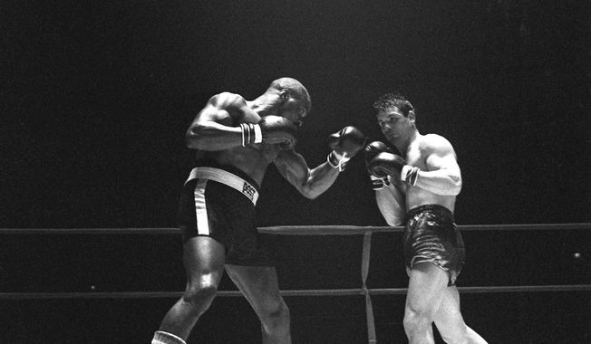 FILE - In this Feb. 23, 1965 file photo, Rubin &amp;quot;Hurricane&amp;quot; Carter, left, knocks out Italian boxer Fabio Bettini in the 10th and last round of their fight at the Falais Des Sports in Paris. Carter, who spent almost 20 years in jail after twice being convicted of a triple murder he denied committing, died at his home in Toronto, Sunday, April 20, 2014, according to long-time friend and co-accused John Artis. He was 76. (AP Photo/File)