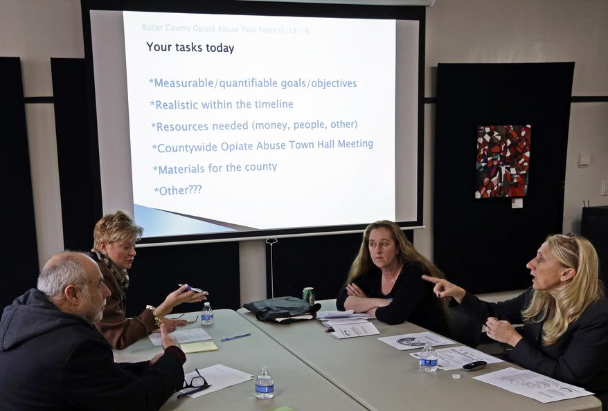 In this Feb. 18, 2014 photo, Susan Cross Lipnickey, right, an attorney and a Miami University associate professor, leads a meeting of the Butler County Opiate Abuse Task Force in Hamilton, Ohio. The task force is a loosely knit group of social services officials, addiction experts, educators, parents of addicts and other community activists. (AP Photo/Al Behrman)