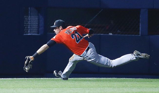 Miami Marlins left fielder Christian Yelich (21) can&#x27;t reach a ball hit for  double by Atlanta Braves pinch hitter Jordan Schafer in the ninth inning of a baseball game Monday, April 21, 2014 in Atlanta.  Atlanta won 4-2 in the tens innings. (AP Photo/John Bazemore)
