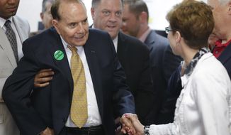 Former Sen. Bob Dole, R-Kan., second from left, greets former Mission Mayor Laura McConwell, right, at Johnson County Republican Headquarters in Overland Park, Kan., Monday, April 21, 2014. (AP Photo/Orlin Wagner)