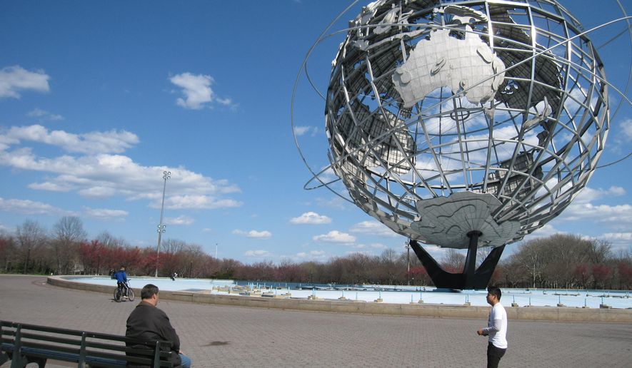 In this April 9, 2014, photo, a man walks near the Unisphere, a 12-story steel globe that debuted 50 years ago at the 1964 World’s Fair in the Queens borough of New York. It’s located in Flushing Meadows Park outside the Queens Museum of Art, and it’s one of a number of World’s Fair sites that is still in place. (AP Photo/Beth J. Harpaz)