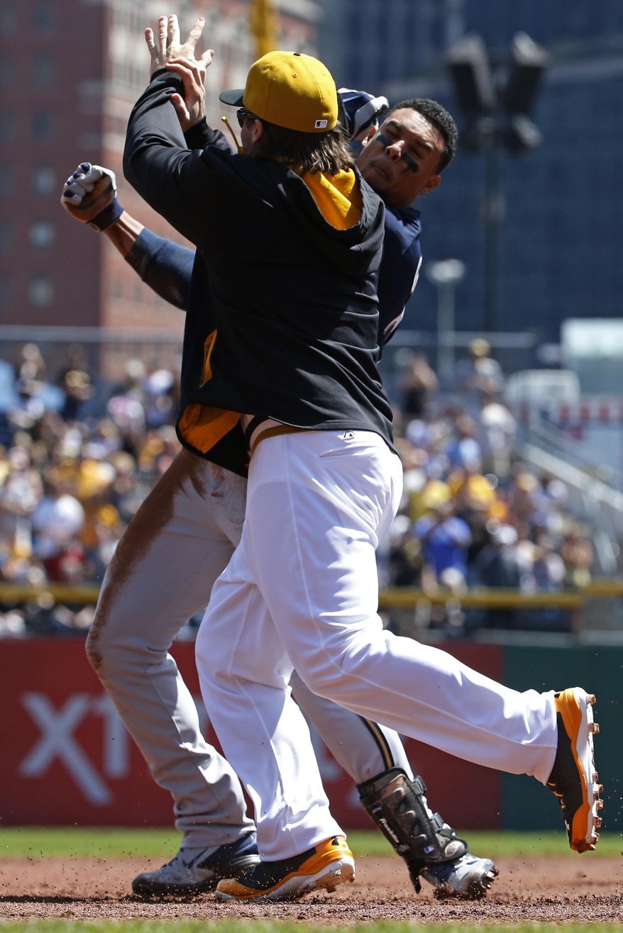 Pittsburgh Pirates' Travis Snider, left, takes down Milwaukee Brewers' Carlos Gomez during a skirmish between the teams during the third inning of a baseball game in Pittsburgh, Sunday, April 20, 2014. Gomez and Snider were ejected from the game. (AP Photo/Gene J. Puskar)