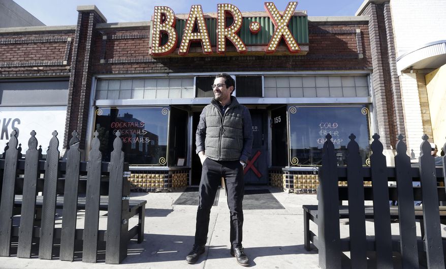 In this April 16, 2014 photo, actor Ty Burrell, who plays bumbling dad Phil Dunphy on ABC's “Modern Family,” stands outside Bar X, the cocktail bar he co-owns, in Salt Lake City. Burrell just opened Beer Bar, a beer garden-like eatery next door to Bar X that serves 150 beers paired up with an array of house-made bratwursts, local breads and Belgian fries. The restaurant sports long tables and benches with high ceilings to evoke that Bavarian beer hall feel. (AP Photo/Rick Bowmer)
