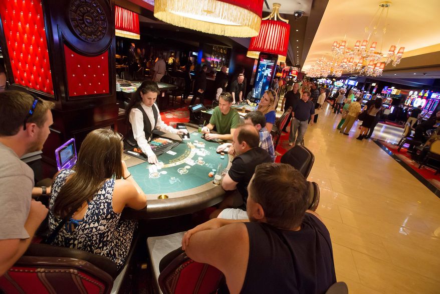 ** FILE ** This April 21, 2014, photo provided by The Cromwell shows patrons playing blackjack on the at The Cromwell Hotel and Casino as it opens for business. Slot machines are now ringing at the boutique hotel replacing Bill's Gamblin' Hall & Saloon in the heart of the Las Vegas Strip. (AP Photo/The Cromwell, Erik Kabik)