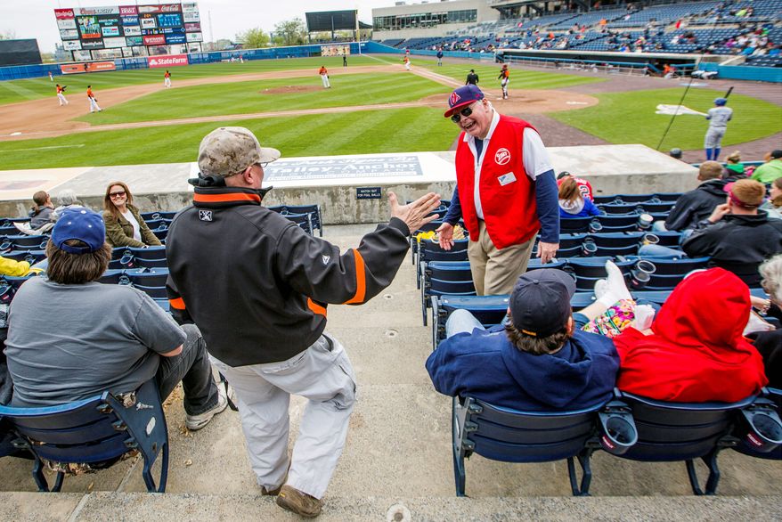 Navy Cmdr. Steven Dundas greets usher Art Morgan at the Norfolk Tides' game at Harbor Park in Norfolk, Va., on Sunday. Years after his diagnosis of post-traumatic stress disorder, he continues to try to cope with his symptoms. (Eva Russo/Special to The Washington Times)