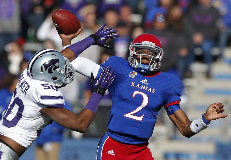 FILE - In this Nov. 30, 2013 file photo, Kansas quarterback Montell Cozart (2) passes over Kansas State linebacker Tre Walker (50) during the first half of an NCAA college football game in Lawrence, Kan. Cozart has won the starting job at Kansas, beating out Jake Heaps and T.J. Millweard after a strong spring game. (AP Photo/Orlin Wagner, File)