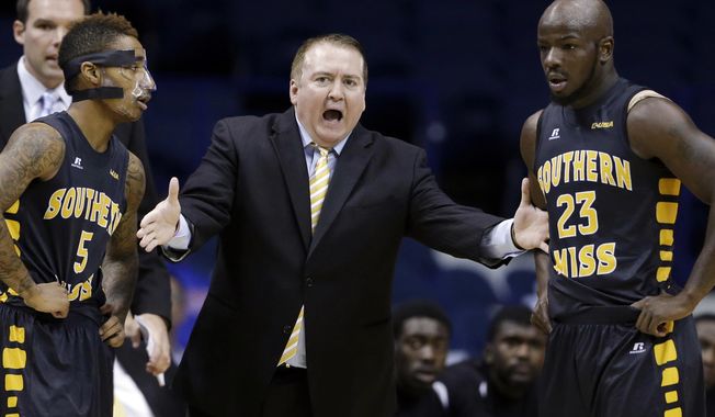 FILE - In this Nov. 13, 2013 file photo, Southern Mississippi head coach Donnie Tyndall, center, talks to guards Neil Watson, left, and Jerrold Brooks during the first half of an NCAA college basketball game against DePaul, in Rosemont, Ill. Tennessee is counting on Tyndall to make the same successful transition from the mid-major ranks as the Volunteers&#x27; last two men&#x27;s basketball coaches. Tennessee announced Tuesday morning, April 22, 2014, that Tyndall would be introduced as its new coach at a 2 p.m. news conference. (AP Photo/Nam Y. Huh, File)