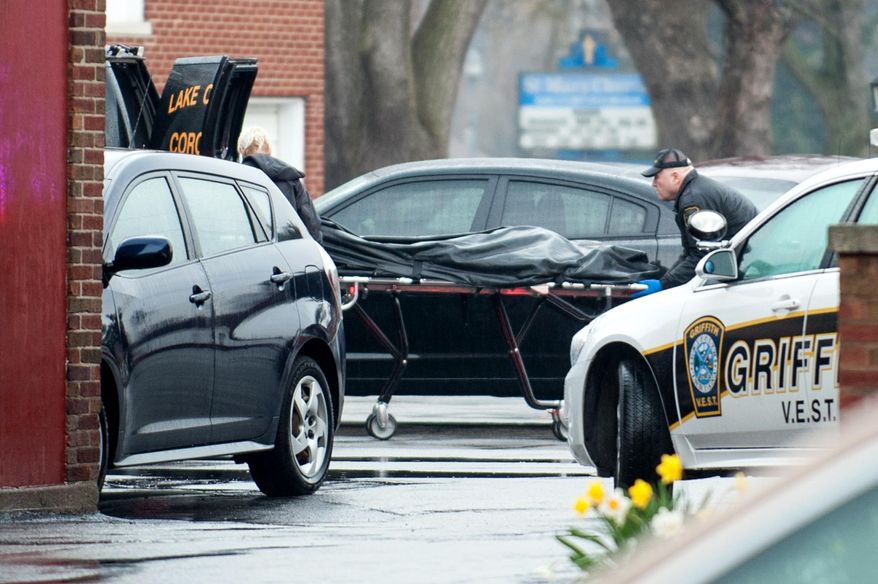 In this photo taken April 21, 2014, a body bag is rolled into a coroner's van at the scene of a fatal shooting in the parking lot at St. Mary's School in Griffith, Ind. Nina Castro, 42, was shot to death by her estranged husband, Remanard Castro, 55, who later died of a self-inflicted gunshot wound at his home after a police officer confronted him, police said. (AP Photo/The Times, Kyle Telechan) MANDATORY CREDIT; CHICAGO LOCALS OUT; GARY OUT.