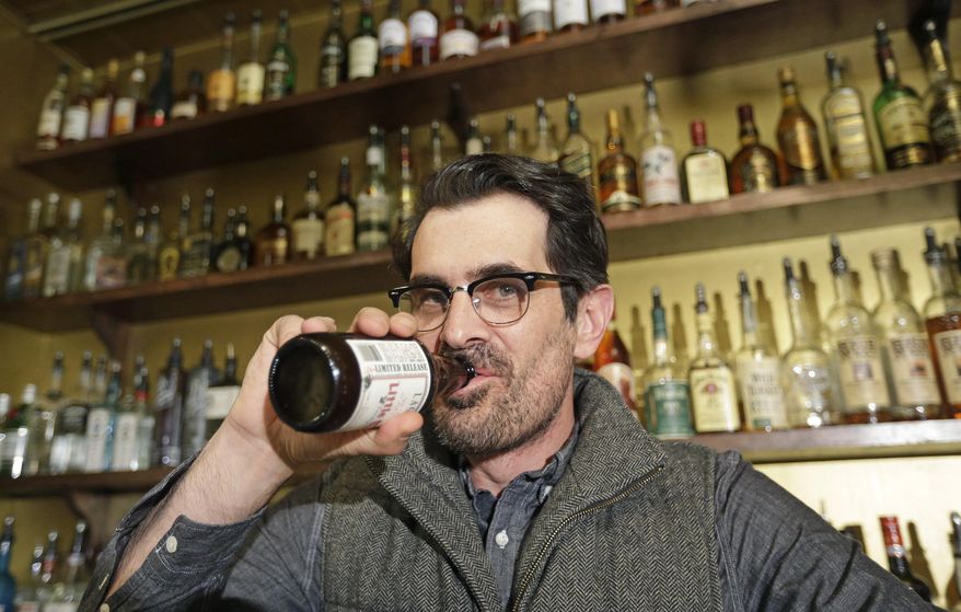 In this April 16, 2014 photo, actor Ty Burrell, who plays bumbling dad Phil Dunphy on ABC's “Modern Family,” drinks a beer at Bar X, the cocktail bar he co-owns, in Salt Lake City. Burrell just opened Beer Bar, a beer garden-like eatery next door to Bar X that serves 150 beers paired up with an array of house-made bratwursts, local breads and Belgian fries. The restaurant sports long tables and benches with high ceilings to evoke that Bavarian beer hall feel. (AP Photo/Rick Bowmer)