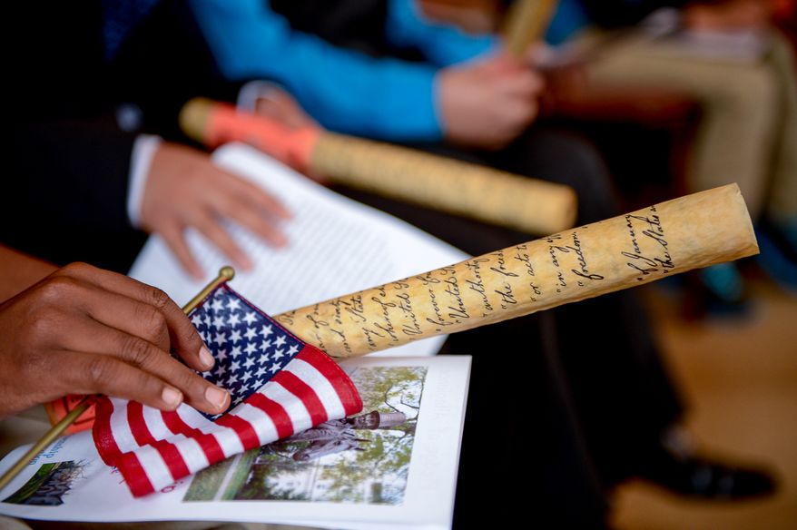 Children are given copies of the Emancipation Proclamation before taking their Naturalization Oath of Allegiance at Lincoln's Cottage, Washington, D.C., Tuesday, April 22, 2014. Twenty area children representing 15 countries receive their Certificates of Citizenship during a special ceremony at President Lincoln's Cottage, where it is believed President Abraham Lincoln drafted the Emancipation Proclamation. (Andrew Harnik/The Washington Times)
