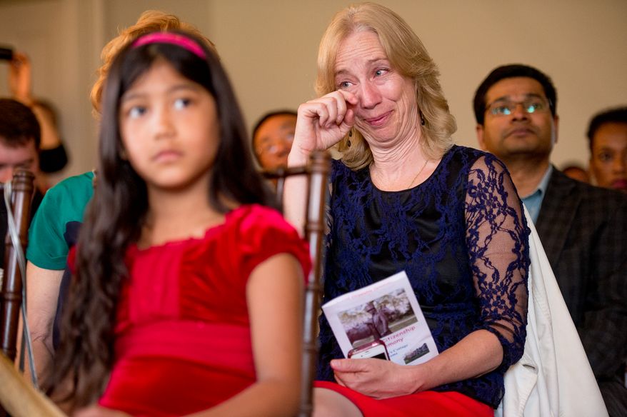 Brenda Sue Thorton, of Washington, D.C. wipes tears from her eyes after her daughter Sujata Andres Thorton from Nepal take her Naturalization Oath of Allegiance at Lincoln's Cottage, Washington, D.C., Tuesday, April 22, 2014. Twenty area children representing 15 countries receive their Certificates of Citizenship during a special ceremony at President Lincoln's Cottage, where it is believed President Abraham Lincoln drafted the Emancipation Proclamation. (Andrew Harnik/The Washington Times)