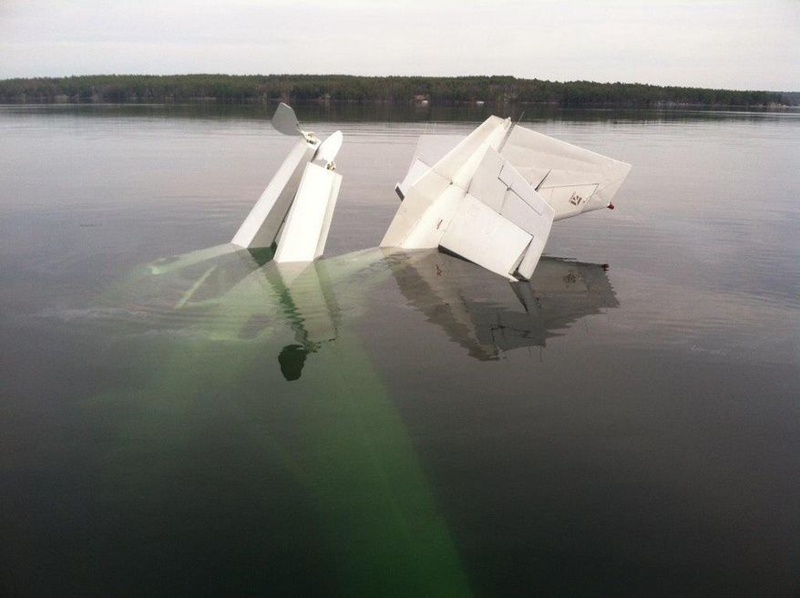 In this photo provided by the New Hampshire State Police, a small plane lies partially submerged after crashing in New Hampshire's Lake Winnipesaukee, Tuesday, April 22, 2014. New Hampshire State Police say the pilot, who was found submerged in water and clinging to the plane, was the only occupant and was rescued. (AP Photo/New Hampshire State Police)