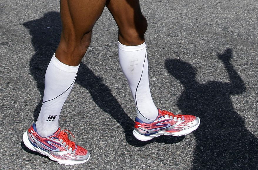 In this Monday, April 21, 2014 photo, Meb Keflezighi limbers up in Hopkinton, Mass., before running in -- and winning -- the 118th Boston Marathon. Keflezighi’s title is a boost for his sponsor, Skechers, which is trying to prove it can produce high-performance running shoes. (AP Photo/Stephan Savoia)