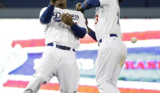 Los Angeles Dodgers&#39; Carl Crawford, left, and Hanley Ramirez misses the ball hit by Philadelphia Phillies&#39; Carlos Ruiz during the 10th inning of a baseball game on Tuesday, April 22, 2014, in Los Angeles. (AP Photo/Jae C. Hong)
