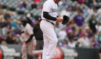 Colorado Rockies relief pitcher Chad Bettis reacts after giving up a grand slam to San Francisco Giants&#39; Hector Sanchez, rear, in the 11th inning of the Giants&#39; 12-10 victory in 11 innings in a baseball game in Denver on Wednesday, April 23, 2014. (AP Photo/David Zalubowski)