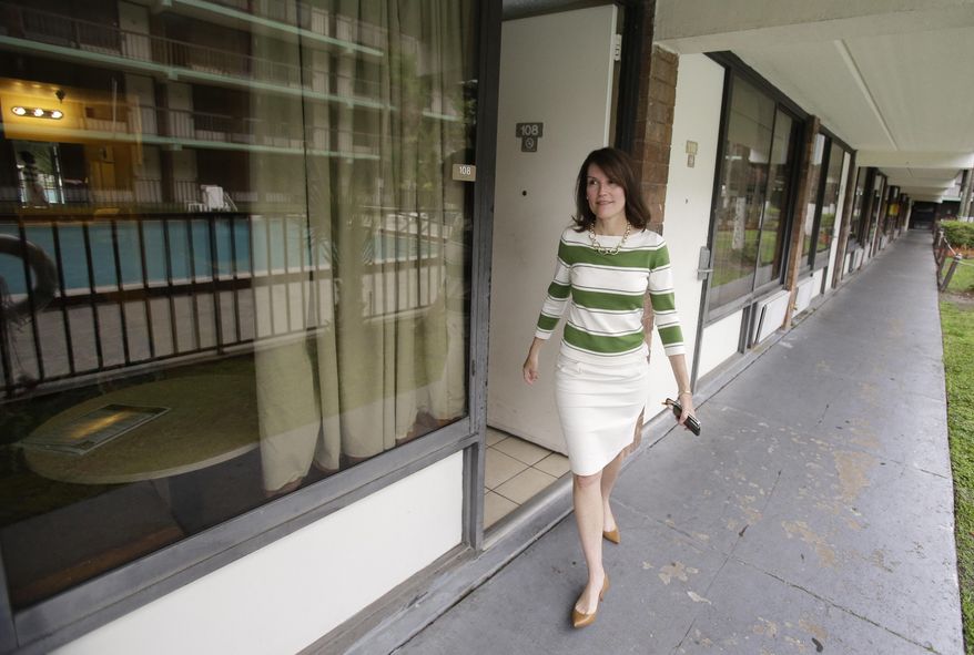 In this Tuesday, April 8, 2014 photo,  hotel owner Dianna Chane walks by rooms at her extended stay hotel in Kissimmee, Fla. She claims she can't get local law enforcement to help her evect tenants that don't pay for rooms. (AP Photo/John Raoux)