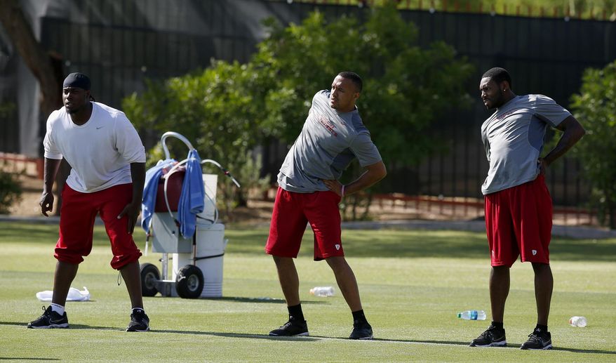 From left to right, Arizona Cardinals&#x27; Marcus Benard, Michael Floyd and Antonio Cromartie stretch during the first phase of the voluntary offseason training program at the NFL football team&#x27;s training facility on Thursday, April 24, 2014, in Tempe, Ariz. (AP Photo/Ross D. Franklin)