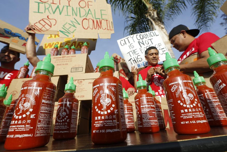 Sriracha hot sauce bottles are set by supporters protesting ahead of the city council meeting in Irwindale, Calif., Wednesday, April 23, 2014. The Irwindale City Council has declared that the factory that produces the popular Sriracha hot sauce is a public nuisance. (AP Photo/Damian Dovarganes)