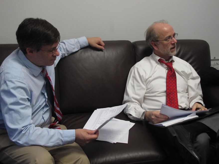 Sens. Bill Wielechowski and Holllis French go over education funding amounts after a conference committee proposed a compromise education bill on Wednesday, April 23, 2014, in Juneau, Alaska. The two Anchorage Democrats were in French's office. French is the Senate minority leader. (AP Photo/Becky Bohrer)