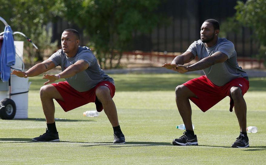 Arizona Cardinals&#x27; Michael Floyd, left, and Antonio Cromartie stretch during the first phase of the voluntary offseason training program at the NFL football team&#x27;s training facility on Thursday, April 24, 2014, in Tempe, Ariz. (AP Photo/Ross D. Franklin)