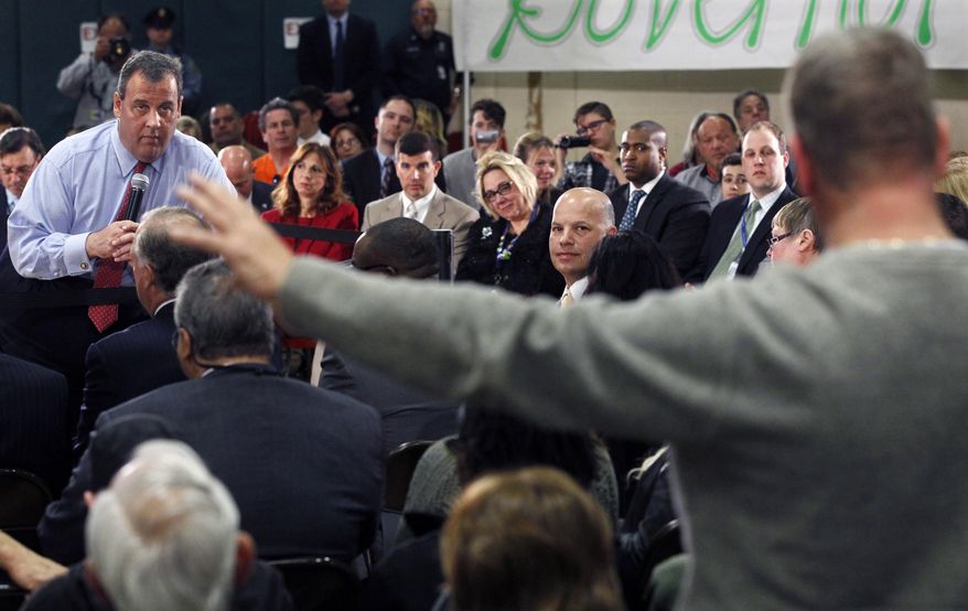 New Jersey Gov. Chris Christie, left, listens to a question during a town hall meeting in Brick Township, N.J., Thursday, April 24, 2014. Many questions at the town hall focused on the state's Sandy recovery efforts. (AP Photo/Mel Evans)