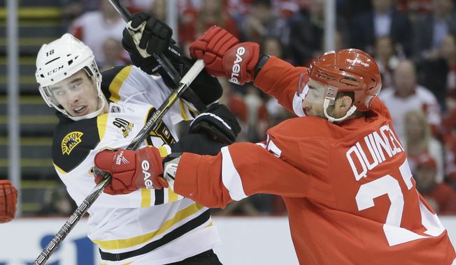 Detroit Red Wings defenseman Kyle Quincey (27) checks Boston Bruins right wing Reilly Smith during the first period of Game 4 of a first-round NHL hockey playoff series in Detroit, Thursday, April 24, 2014. (AP Photo/Carlos Osorio)
