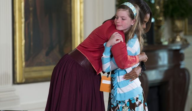 First lady Michelle Obama hugs Charlotte Bell, 10, after she handed Mrs. Obama her dad&#x27;s resume during the White House&#x27;s annual &quot;Take Our Daughters and Sons to Work Day,&quot; Thursday, April 24, 2014, in the East Room of the White House in Washington. The girl in the front row at Thursday&amp;#8217;s event told the first lady that her dad had been out of work for three years. Then the girl popped up to hand Mrs. Obama her dad&amp;#8217;s resume saying &amp;#8220;My dad&amp;#8217;s been out of a job for three years and I wanted to give you his resume.&amp;#8221; (AP Photo/ Evan Vucci)