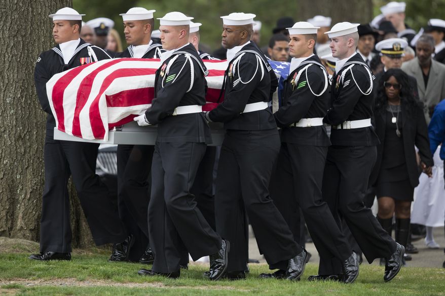 A U.S. Navy honor guard carries the casket of U.S. Navy Petty Officer 2nd Class Mark Mayo, of Hagerstown, Md., during a burial service at Arlington National Cemetery in Arlington, Va., Friday, April 25, 2014.  Mayo was killed aboard the USS Mahan at Naval Station Norfolk, Va., after he dove in front of another sailor to protect her from a civilian truck driver who had seized her gun. Mayo was awarded the Navy Marine Corps Medal, the highest non-combatant decoration for heroism by a sailor or Marine. (AP Photo/ Evan Vucci)