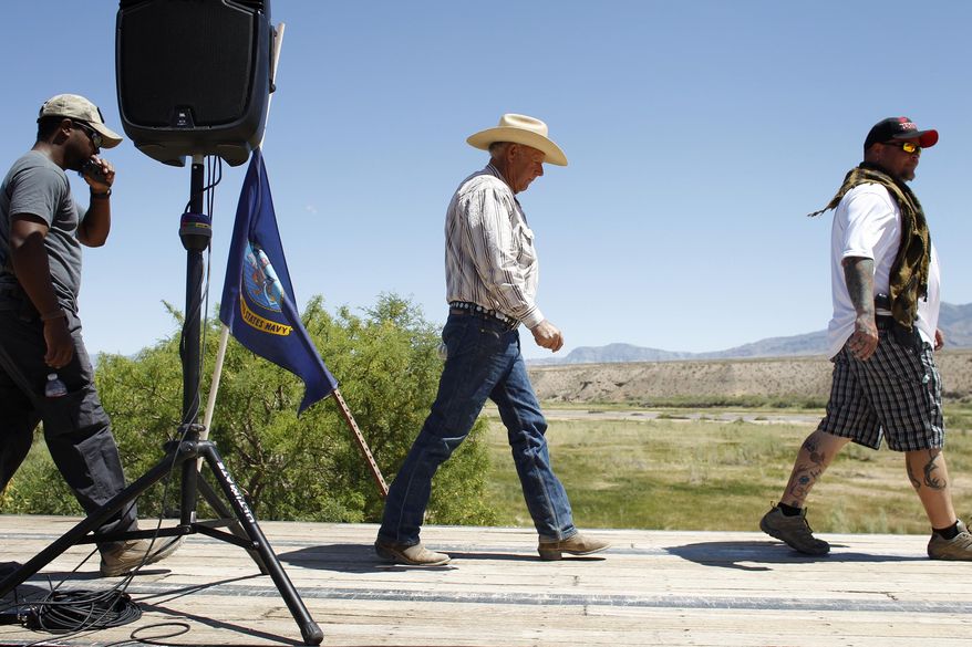 Rancher Cliven Bundy, center, walks on stage to speak at a press conference near Bunkerville, Nev., Thursday, April 24, 2014. Bundy, a Nevada rancher who became a conservative folk hero for standing up to the government in a fight over grazing rights, lost some of his staunch defenders Thursday after wondering aloud whether blacks might have had it better under slavery. (AP Photo/Las Vegas Review-Journal, John Locher)