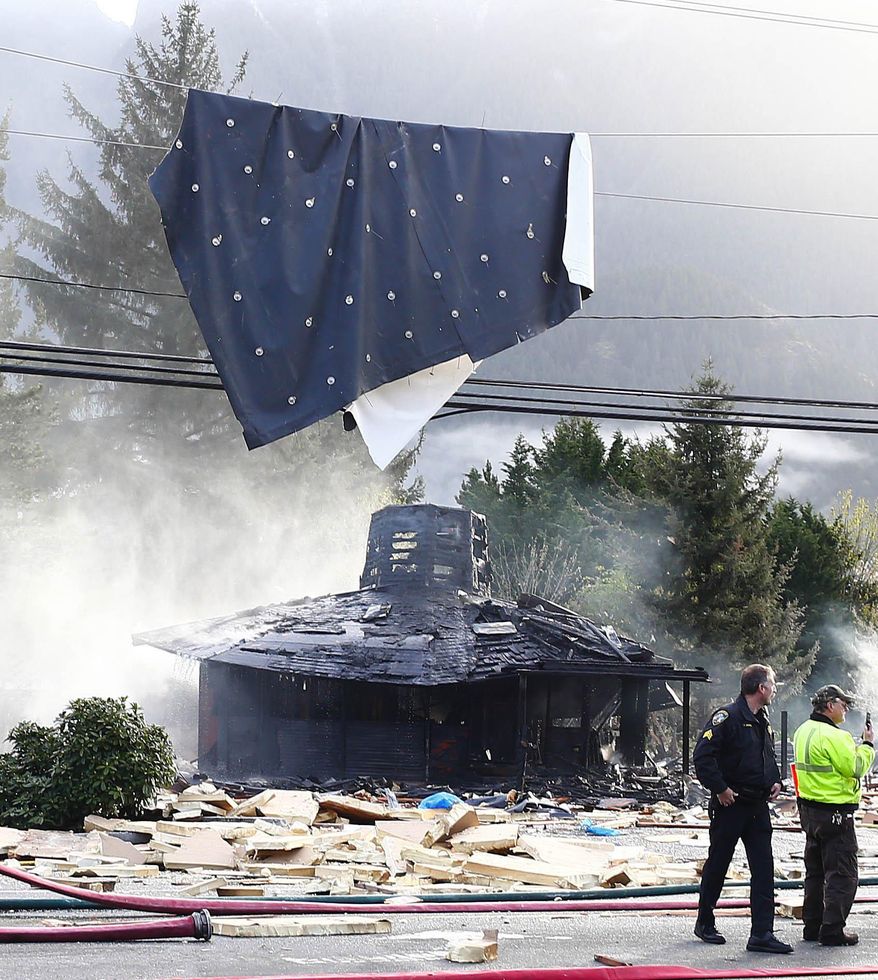 Debris is strewn on and above the roadway after a large explosion in North Bend, Wash., on Friday, April 25, 2014. A big explosion and fire destroyed three buildings, damaged several others, sent debris flying for blocks and jolted people awake early Friday, firefighters and North Bend residents said. (AP Photo/The Seattle Times, John Lok) SEATTLE OUT; USA TODAY OUT; MAGS OUT; TELEVISION OUT; NO SALES; MANDATORY CREDIT TO BOTH THE SEATTLE TIMES AND THE PHOTOGRAPHER