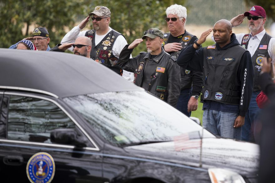 Members of the Patriot Guard salute as the casket of U.S. Navy Petty Officer 2nd Class Mark Mayo, of Hagerstown, Md., arrives during a burial service at Arlington National Cemetery in Arlington, Va., Friday, April 25, 2014.  Mayo was killed aboard the USS Mahan at Naval Station Norfolk, Va., after he dove in front of another sailor to protect her from a civilian truck driver who had seized her gun. Mayo was awarded the Navy Marine Corps Medal, the highest non-combatant decoration for heroism by a sailor or Marine. (AP Photo/ Evan Vucci)