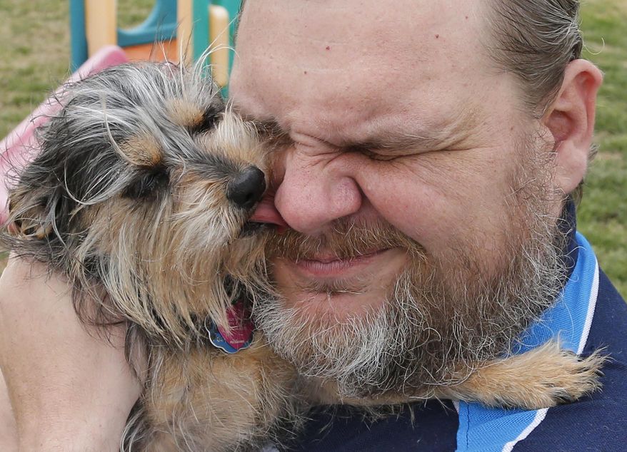 Jerry Starr is pictured with Tobi, his four-year-old shih tzu-yorkie mix dog at a park in Del City, Okla., Thursday, April 17, 2014. Starr was not allowed to take the dog into a shelter during the May 20, 2013 tornado and opted to stay outside the shelter in his car with his dog. (AP Photo/Sue Ogrocki)