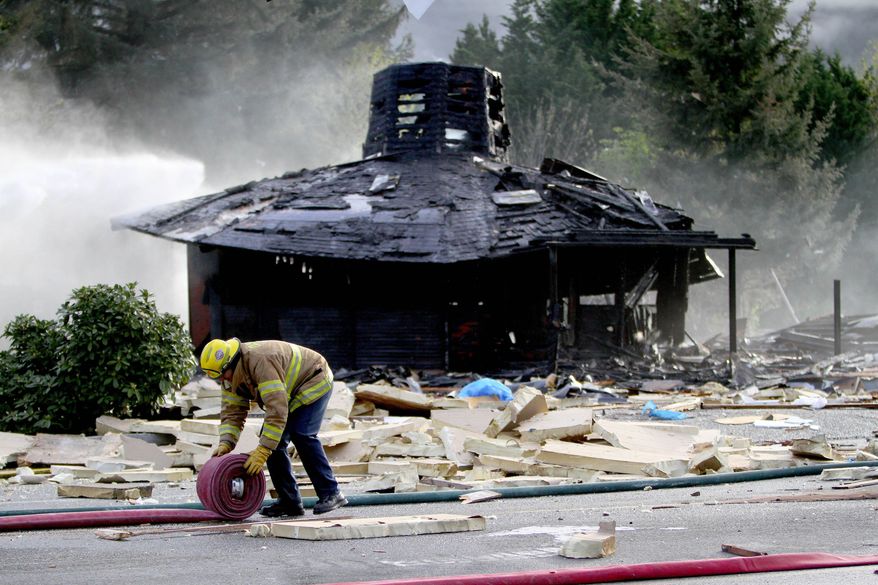 A firefighter works at the scene of a large explosion in North Bend, Wash., on Friday, April 25, 2014. The big explosion and fire destroyed three buildings, damaged several others, sent debris flying for blocks and jolted people awake early Friday, firefighters and North Bend residents said. (AP Photo/The Seattle Times, John Lok) SEATTLE OUT; USA TODAY OUT; MAGS OUT; TELEVISION OUT; NO SALES; MANDATORY CREDIT TO BOTH THE SEATTLE TIMES AND THE PHOTOGRAPHER