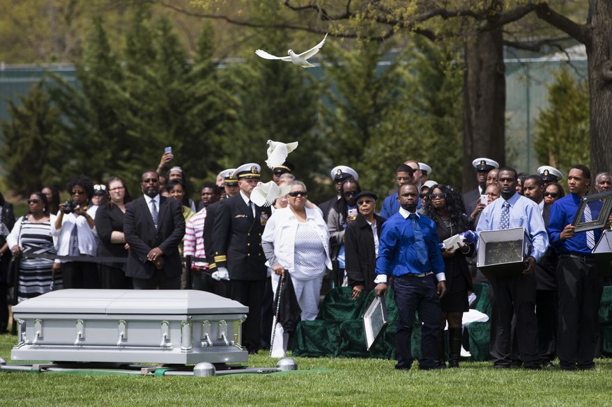 The family of U.S. Navy Petty Officer 2nd Class Mark Mayo, of Hagerstown, Md., release doves during a burial at Arlington National Cemetery in Arlington, Va., Friday, April 25, 2014.  Mayo was killed aboard the USS Mahan at Naval Station Norfolk, Va., after he dove in front of another sailor to protect her from a civilian truck driver who had seized her gun. Mayo was awarded the Navy Marine Corps Medal, the highest non-combatant decoration for heroism by a sailor or Marine. (AP Photo/ Evan Vucci)