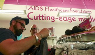 In a Saturday April 19, 2014 photo, Alfonso Serrano, left, and Mark Carrigan shop during the grand opening at the Out of the Closet Thrift Store in Dallas. The stores are part of the AIDS Healthcare Foundation and 96 cents of every dollar earned  goes into supporting AHF clinics serving nearly 300,000 people worldwide. (AP Photo/The Dallas Morning News, Ron Baselice)