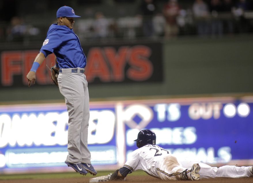 Milwaukee Brewers&#39; Carlos Gomez slides in with a double next to Chicago Cubs shortstop Starlin Castro during the fourth inning of a baseball game Friday, April 25, 2014, in Milwaukee. (AP Photo/Darren Hauck)